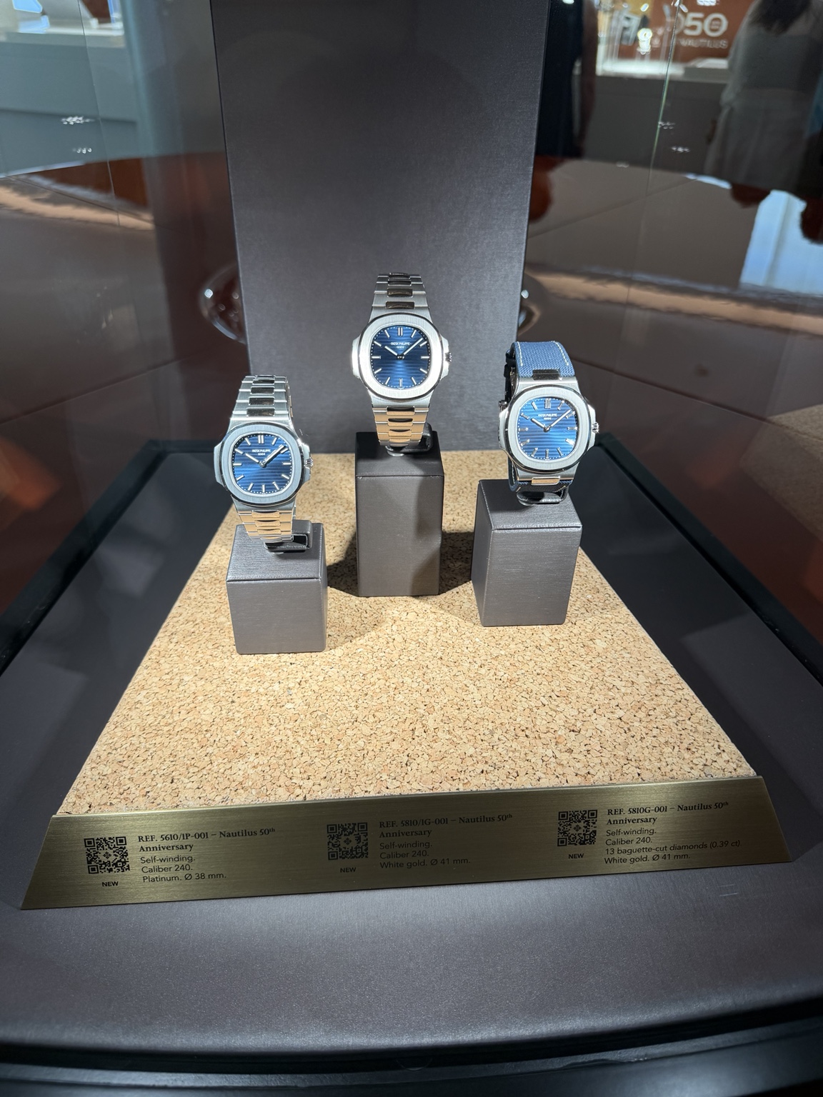 Юбилейные Nautilus 2026: слева 5610/1P-001, в центре 5810/1G-001, справа 5810G-001 — по подписям витрины.